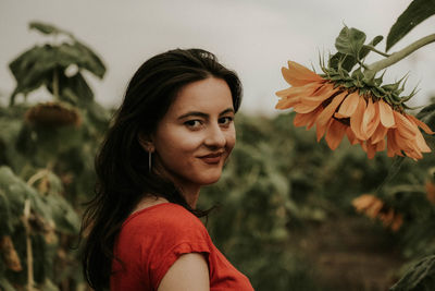 Portrait of young woman standing at sunflower farm