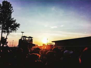 Silhouette of people in city at sunset