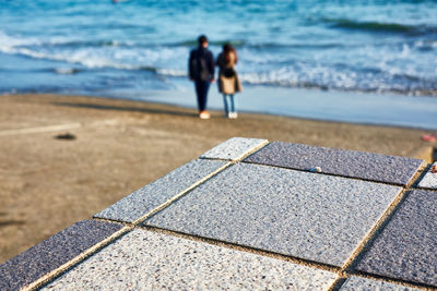 Rear view of people walking on beach
