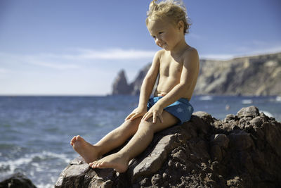 Rear view of shirtless man standing at beach