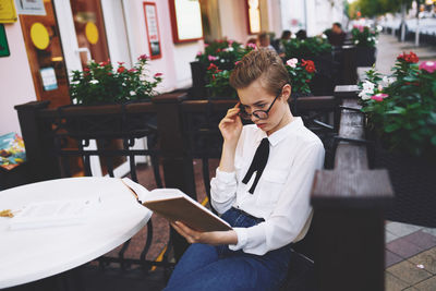 Young woman using mobile phone while sitting at home