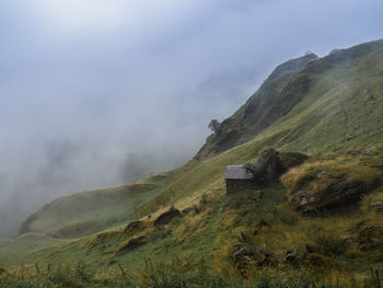 Scenic view of mountain range against cloudy sky