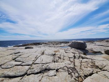 Scenic view of rocks on beach against sky