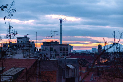 Buildings in city against sky at sunset