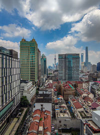High angle view of buildings in city against cloudy sky