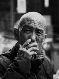 Portrait in black and white of elderly man smoking a cigarette.