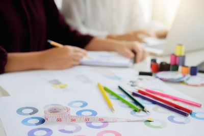 Midsection of female colleagues working at desk in office