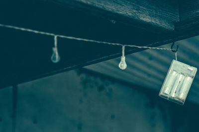 Low angle view of illuminated lighting equipment hanging from ceiling