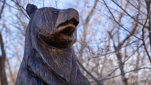 Low angle view of animal statue on bare tree