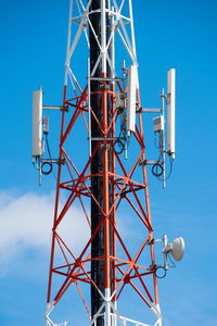 Low angle view of communications tower against blue sky