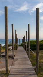 Wooden pier on sea against sky