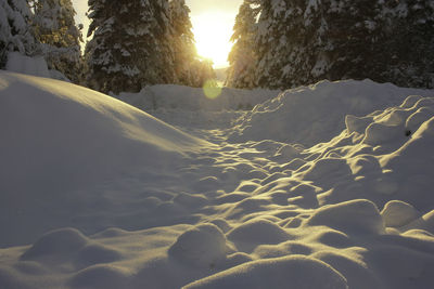 Scenic view of snow covered land against sky during sunset