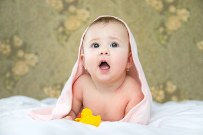 Curious baby girl with towel on head at home