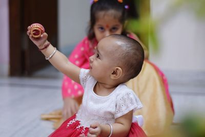 Close-up of cute baby girl holding diya at home