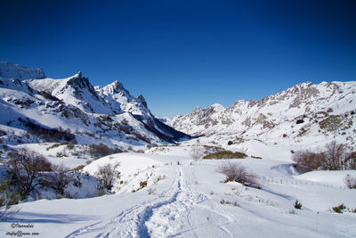 Scenic view of snowcapped mountains against clear blue sky
