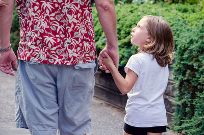 Little girl asking why and many more questions as she walks with grandpa