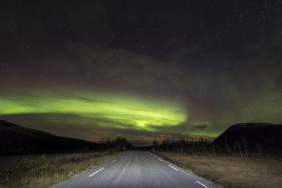 Road amidst landscape against sky at night