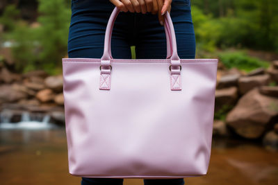 Midsection of woman holding bag