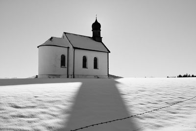 Lighthouse by sea against sky