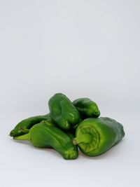 Close-up of green chili pepper against white background