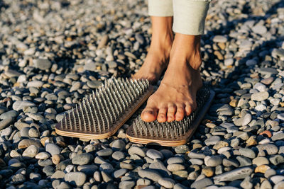Low section of woman standing on stones