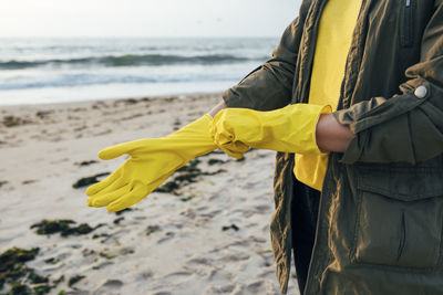 Woman holding yellow while standing on beach