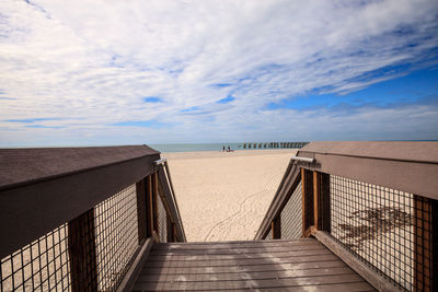 Pier on beach against sky