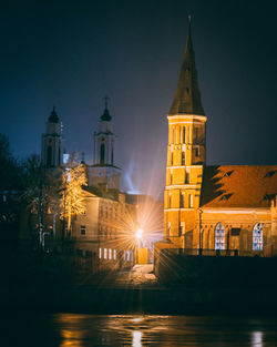 Illuminated buildings against sky at night