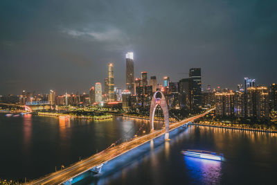 Illuminated buildings in city against sky at night