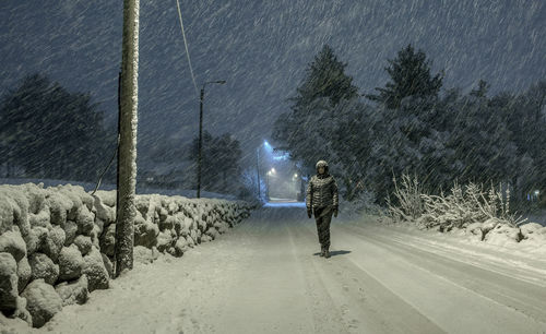 Rear view of woman walking on road