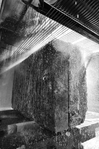 Close-up of water flowing through window of building