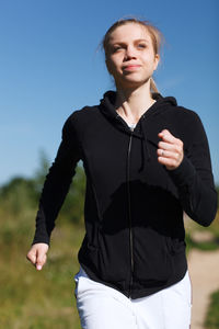 Young woman exercising while running outdoors