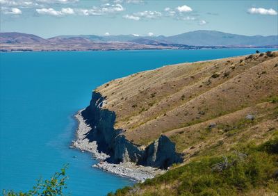 Scenic view of sea and mountains against sky