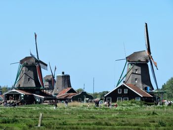 Windmills on field against clear sky