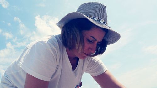 Portrait of young woman looking away against sky