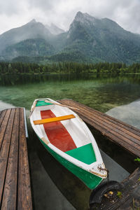 Boats moored on lake against mountains