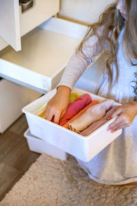 High angle view of woman holding white table at home