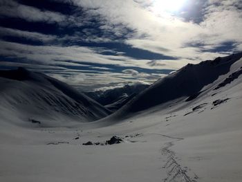 Snow covered mountains against cloudy sky