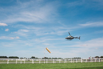 Airplane flying over grass against sky