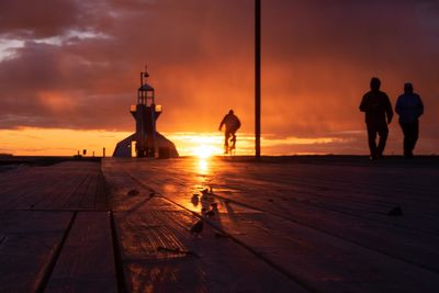 Low angle view of people walking on pier