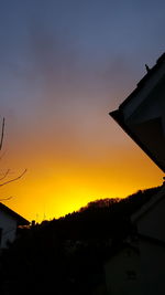 Silhouette city against sky during sunset