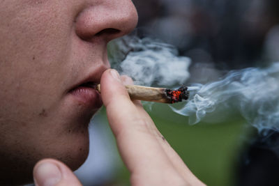 Close-up of human hand holding cigarette