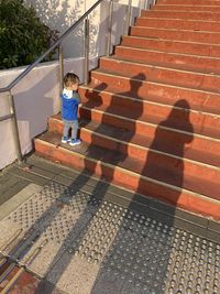 High angle view of boy standing on staircase