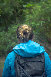 Rear view of backpack woman during rainy season