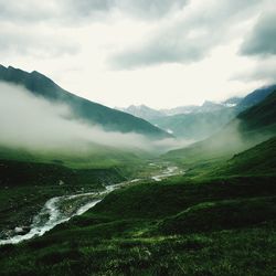 Scenic view of mountain against cloudy sky