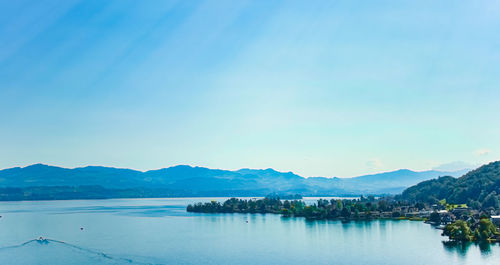 Scenic view of lake against clear blue sky