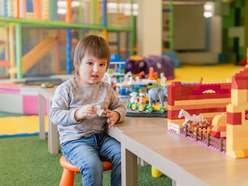 Portrait of cute girl playing with toys in library