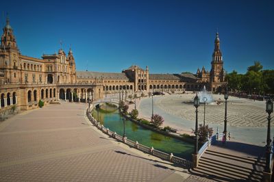 View of historic buildings in city against clear blue sky