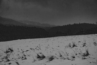 Scenic view of snow covered field against sky