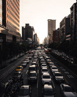 Traffic on city street amidst buildings against sky